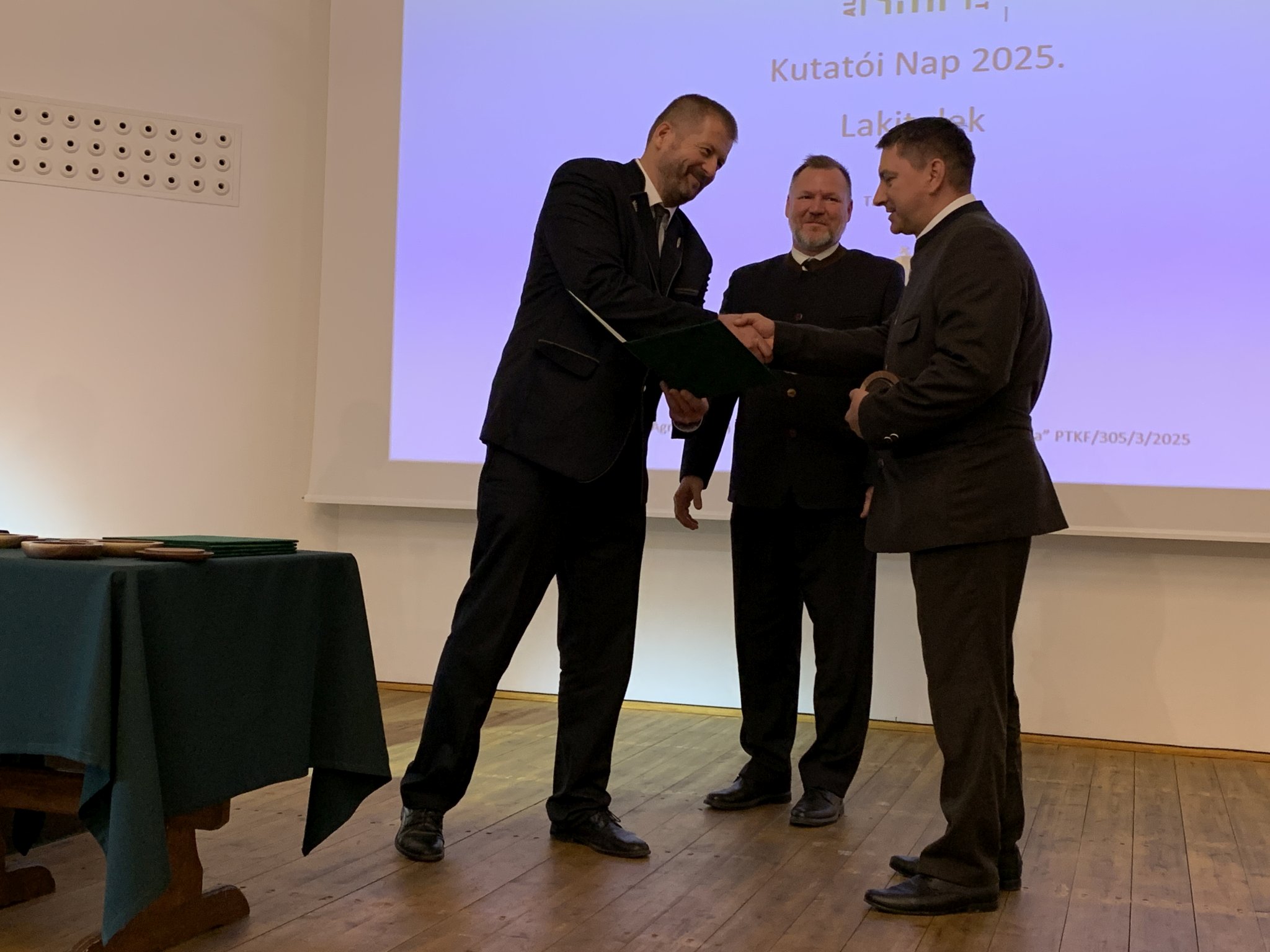 4. kép: Csala Flórián kerületvezető erdész (j) részére az Alföldi Erdőkért Emlékérmet Sulyok Ferenc (b) az AEE képviseletében, és Fehér Sándor a NEFAG Zrt. vezérigazgatója (k) adják át.